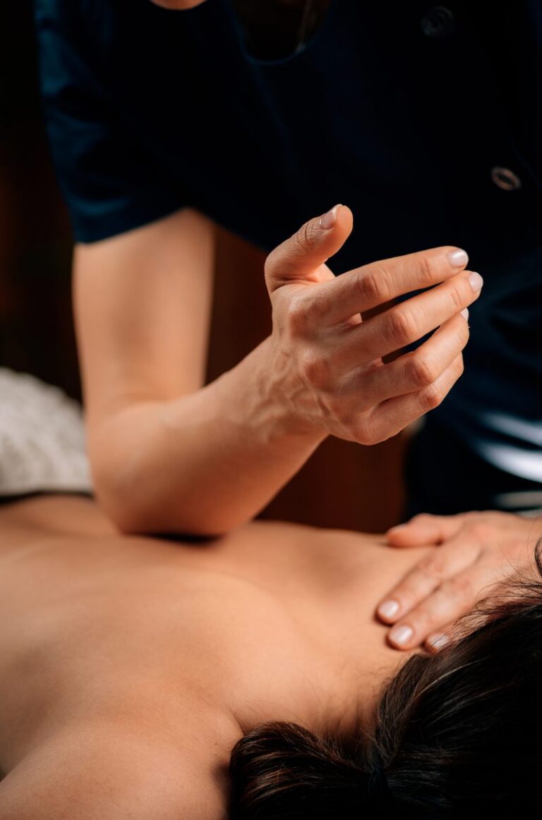 Massage therapist using an elbow to work a client's upper back